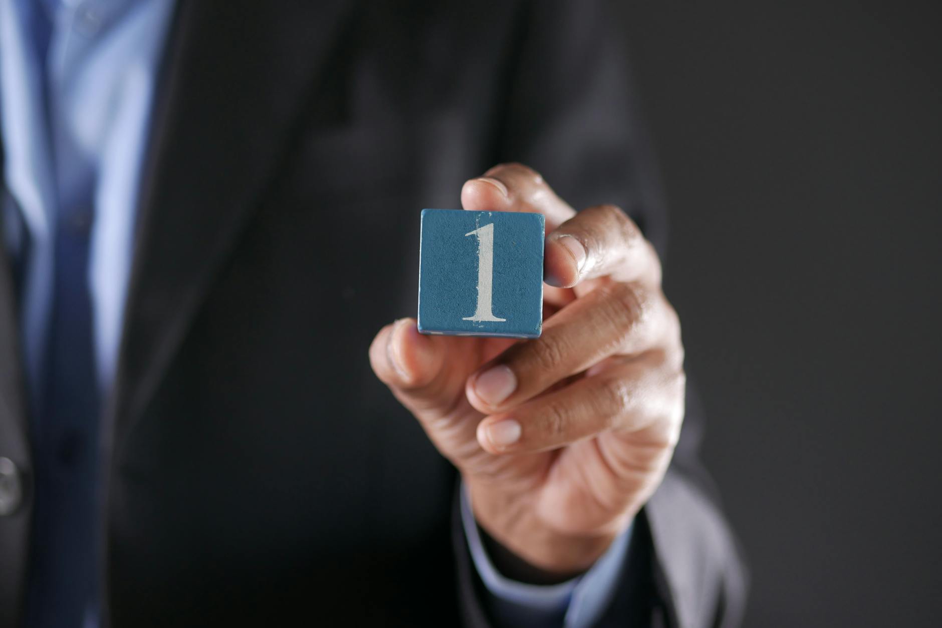 a close up shot of a person holding a block with a number